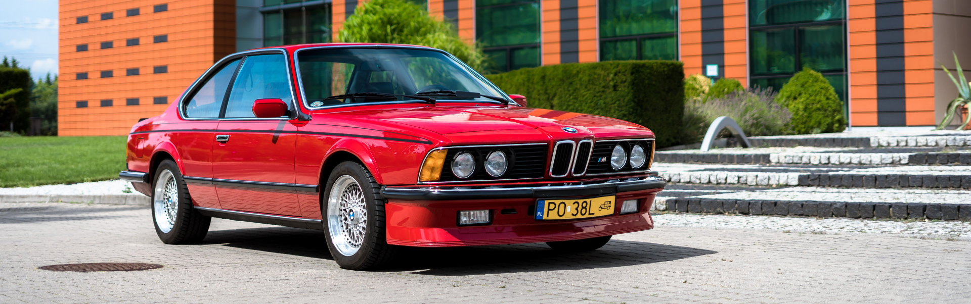 Kalsyczny samochód na tle budynku firmy NOVOL odrestaurowany przy użyciu produktów NOVOL for Classic Cars Realizacje – video - NOVOL FOR CLASSIC CARS